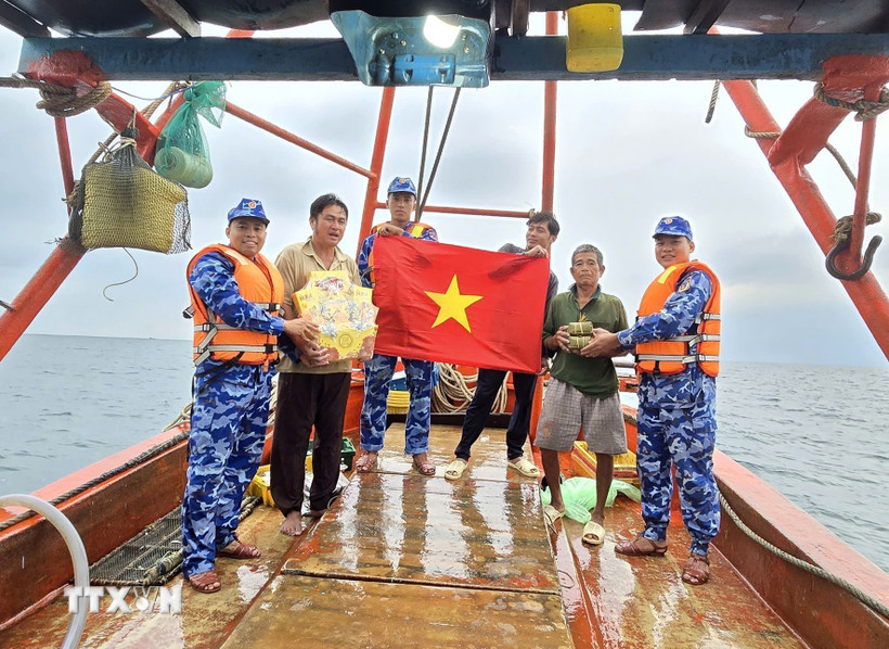 Cán bộ, chiến sỹ Tàu CSB 3002 trao tặng cho ngư dân đánh bắt trên ngư trường những phần quà tết giản dị nhưng thấm đượm nghĩa tình quân – dân. (Ảnh: TTXVN phát)