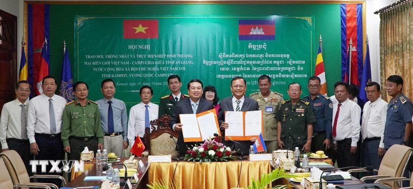 Phó Chủ tịch UBND tỉnh An Giang Lê Trung Hồ (trái) và ngài Khiev Rithiphorn, Phó Tỉnh trưởng tỉnh Kampot ký kết về trao đổi, thống nhất và triển khai Hiệp định Thương mại Biên giới Việt Nam - Campuchia. (Ảnh: TTXVN phát)