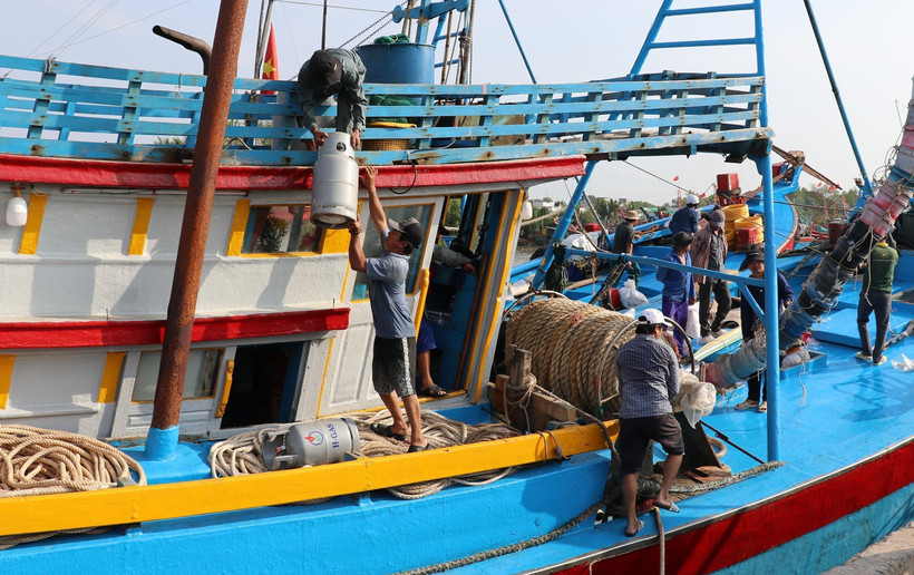 Ngư dân vận chuyển bình gas cho chuyến ra khơi đầu năm mới. (Ảnh: Hữu Chí /TTXVN)