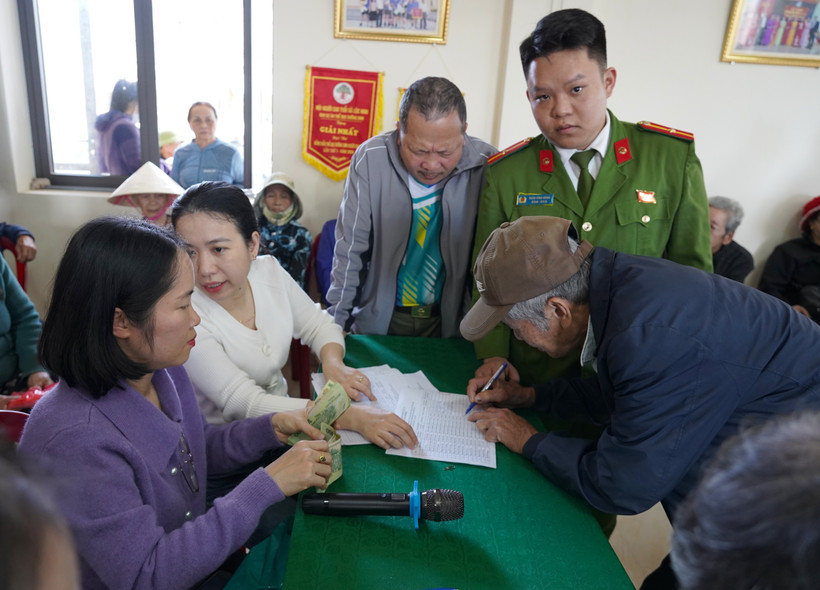 Người dân kí nhận, làm thủ tục để nhận quà của Đảng và Nhà nước. (Ảnh: Thanh Thuỷ/TTXVN)