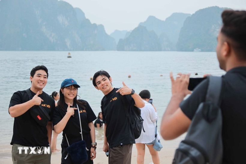 Du khách thích thú chụp ảnh “check in” khi đến với Hạ Long. (Ảnh: Hoàng Hiếu/TTXVN)