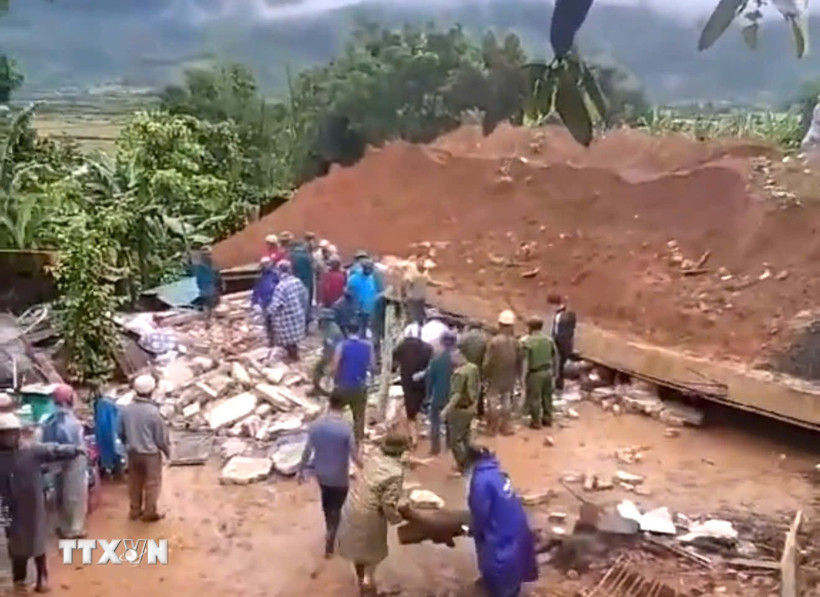 Lực lượng chức năng điều tra nguyên nhân và hỗ trợ gia đình nạn nhân. (Ảnh: TTXVN phát)