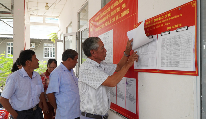 Người dân xem danh sách cử tri được niêm yết tại điểm bỏ phiếu. (Ảnh: Nhựt An/TTXVN)