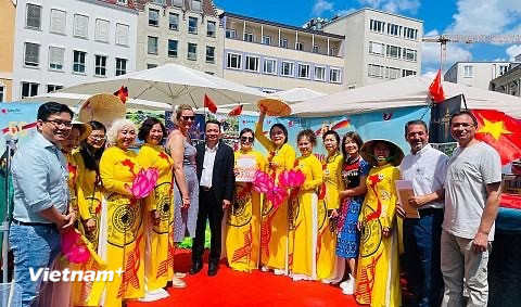 Bà Eva Weber (váy xanh nhạt) - Thị trưởng thành phố Augsburg và ông Phạm Huy Phương (áo vest đen) - Trưởng ban Công tác Cộng đồng Đại sứ quán Việt Nam tại Đức chụp ảnh lưu niệm với cộng đồng người Việt tại thành phố Augsburg. (Ảnh: Vietnam+)