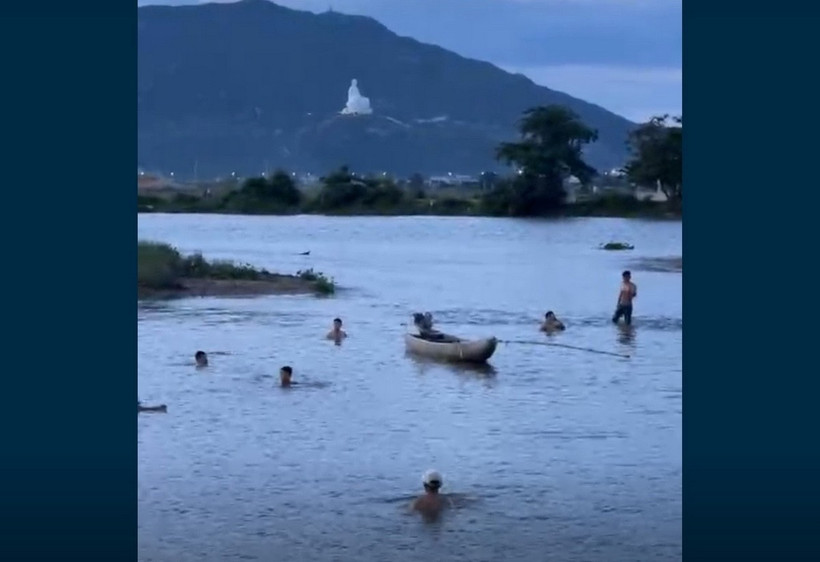 (Ảnh cắt từ clip) Người dân nỗ lực tìm kiếm tại điểm ba học sinh bị đuối nước. (Ảnh: TTXVN phát)