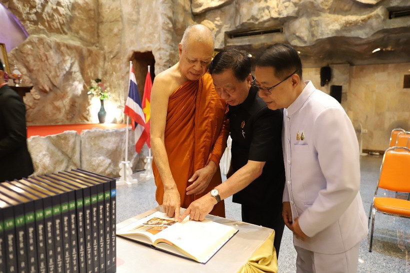 Ngài Surathat Thajasuro (ngoài cùng bên phải), Cố vấn danh dự Quỹ Tam tạng Pali Quốc tế giới thiệu bộ kinh Tam tạng bản tụng đọc với ông Lương Xuân Hòa (giữa), Phó Chủ tịch Tổng Hội Người Việt Nam toàn Thái Lan, Chủ tịch Hội Người Việt Nam tại Udon Thani. (Ảnh: Đỗ Sinh/TTXVN)