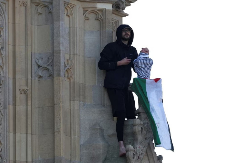 Người đàn ông cầm cờ Palestine trèo lên tháp Big Ben ở London (Anh), ngày 8/3/2025. (Nguồn: Reuters)