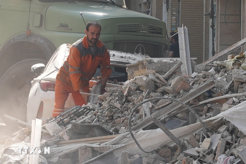 Lực lượng cứu hộ tại hiện trường toà nhà bị phá huỷ sau các vụ không kích của Israel xuống Thủ đô Tehran (Iran) ngày 13/6/2025. (Ảnh: THX/TTXVN)