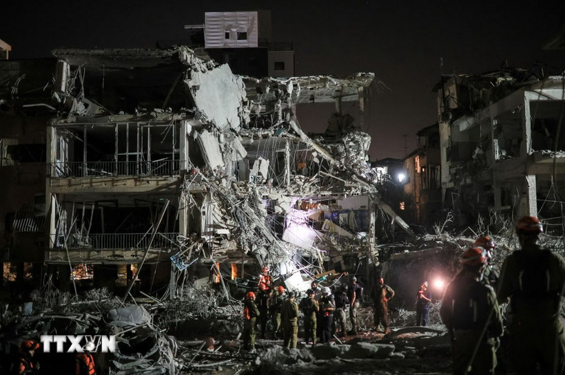 Lực lượng cứu hộ làm nhiệm vụ tại hiện trường đổ nát sau loạt vụ phóng kích của Iran xuống Ramat Gan (Israel) ngày 13/6/2025. (Ảnh: Reuters/TTXVN)