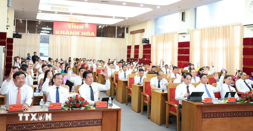 Đại biểu Hội đồng Nhân dân tỉnh Khánh Hòa khóa VII biểu quyết thông qua một nghị quyết tại kỳ họp thứ nhất. (Ảnh: Tiên Minh/TTXVN)