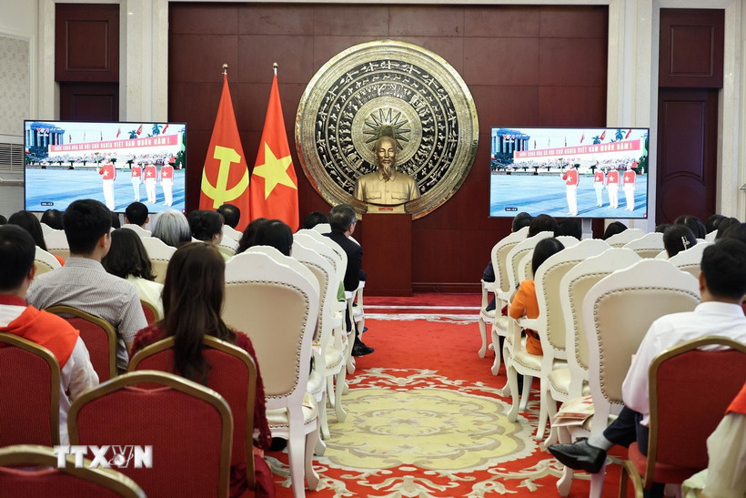 Cán bộ, nhân viên Đại sứ quán và cộng đồng người Việt tại Trung Quốc theo dõi Lễ diễu binh, diễu hành kỷ niệm 80 năm Cách mạng Tháng Tám và Quốc khánh 2/9 qua màn hình nhỏ. (Ảnh: Hải Yến/TTXVN)