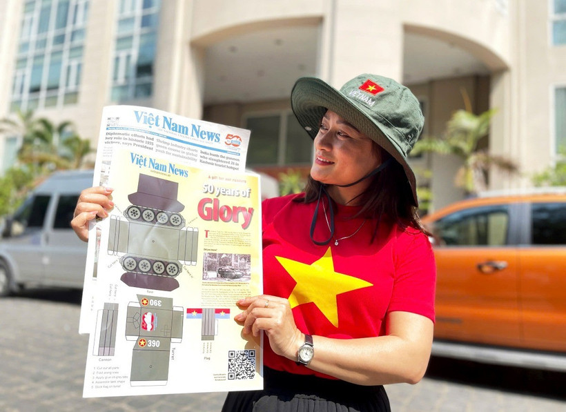 Chị Hoàng Phương (quận 2, Thành phố Hồ Chí Minh) vui mừng sau khi mua ấn phẩm Mô hình cắt dán xe tăng 390 của báo Việt Nam News and Law (Thông tấn xã Việt Nam). (Ảnh: Hồng Đạt)