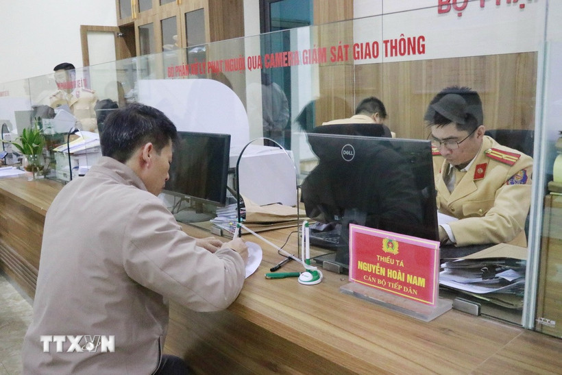 Người dân đến nộp tiền vi phạm tại một bộ phận xử lý phạt nguội qua camera giám sát giao thông. (Ảnh: Đinh Thùy/TTXVN)