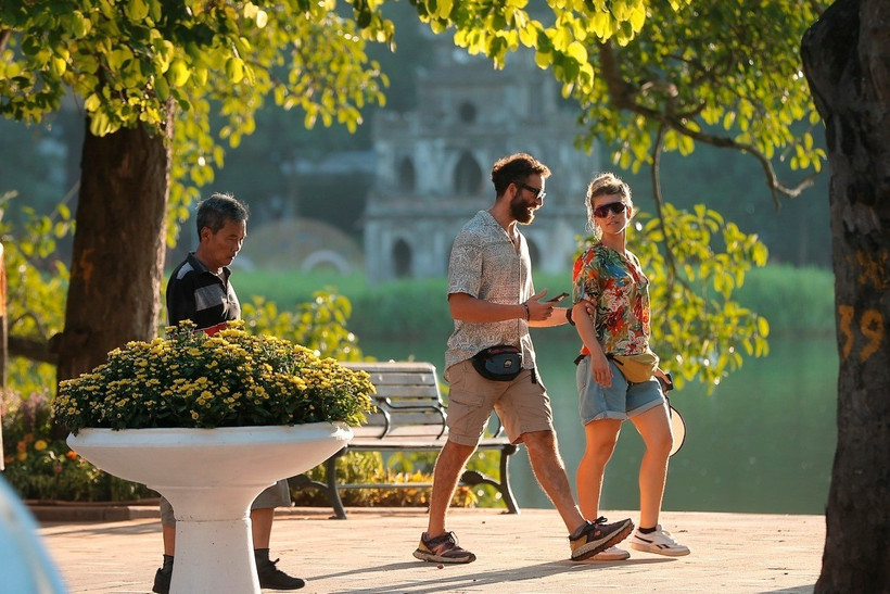 Du khách bên Hồ Hoàn Kiếm (Hà Nội). (Ảnh: Minh Quyết/TTXVN)