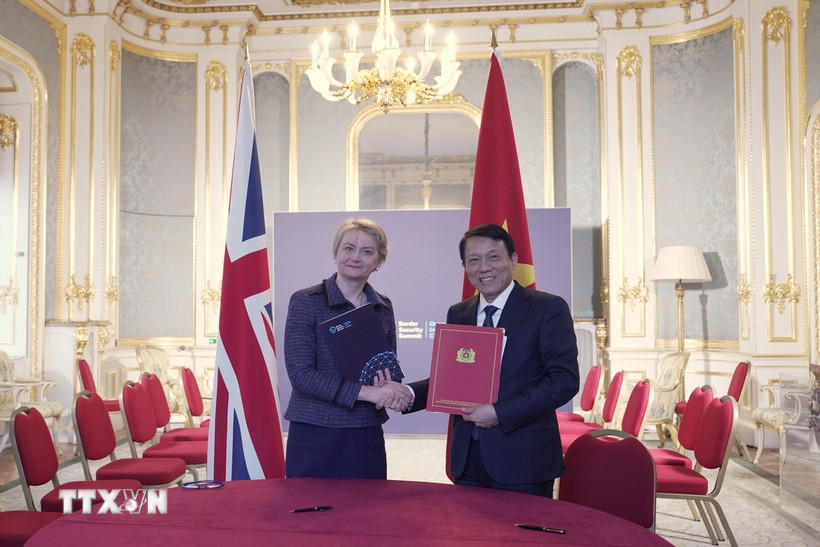 Bộ trưởng Lương Tam Quang (phải) và Bộ trưởng Bộ Nội vụ Anh Yvettte Cooper ký Kế hoạch hành động phòng, chống mua bán người giữa hai Bộ. (Ảnh: TTXVN phát)