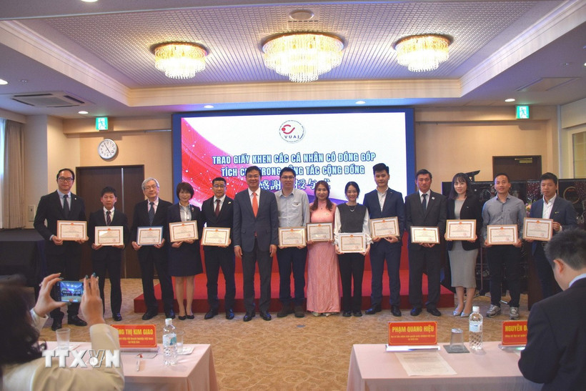 Đại sứ Phạm Quang Hiệu trao tặng giấy khen cho những cá nhân có đóng góp tích cực cho cộng đồng. (Ảnh: Nguyễn Tuyến/TTXVN)