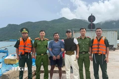 Lực lượng chức năng tiếp cận, tiến hành bắt giữ Trần Văn Phúc lẩn trốn trên tàu cá BT 92907 TS và dẫn giải đối tượng vào bờ. (Ảnh: TTXVN phát)