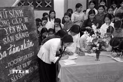 Phong trào phụ nữ “Ba đảm đang” năm 1965 nhanh chóng phát triển thành cao trào cách mạng sôi nổi, rộng lớn, huy động được sức mạnh tổng hợp của hàng chục triệu phụ nữ từ nông thôn tới thành thị, từ miền ngược đến miền xuôi, trên mọi lĩnh vực hoạt động. Trong ảnh: Học sinh trường cấp III Yên Hòa, Hà Nội đăng ký phong trào “Ba đảm nhiệm,' sau này là phong trào phụ nữ “Ba đảm đang”. (Ảnh: Thanh Tụng/TTXVN)