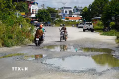 Đường xuống cấp, ngập nặng sau mưa lớn khiến các phương tiện khó khăn khi lưu thông. (Ảnh: Lê Phước Ngọc/TTXVN)