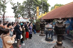 Ngưởi dân Hà Nội đi lễ đầu năm tại chùa Trấn Quốc sáng mùng 1 Tết Ất Tỵ. (Ảnh: Quốc Khánh/TTXVN)