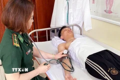 Quân y Bộ đội Biên phòng tỉnh Quảng Ninh chăm sóc sức khỏe cho nạn nhân. (Ảnh: TTXVN phát)