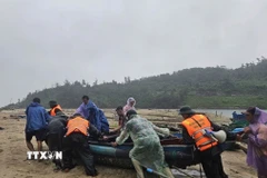 Bộ đội biên phòng giúp dân đưa thuyền vào nơi tránh trú an toàn. (Ảnh: Mai Trang/TTXVN)