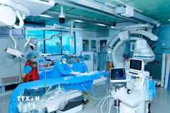 Êkíp các bác sỹ liên chuyên khoa tiến hành can thiệp cứu bệnh nhi. (Ảnh: TTXVN phát)
