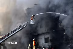 Lính cứu hỏa nỗ lực dập lửa vụ cháy tòa nhà Trung tâm thương mại ở Karachi, Pakistan ngày 18/1/2026. (Ảnh: THX/TTXVN)