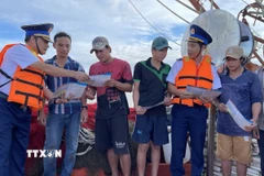 Lực lượng chấp pháp trên biển của Thành phố Hồ Chí Minh tuyên truyền về IUU cho ngư dân thành phố Vũng Tàu trước khi tàu xuất bến ra khơi đánh bắt thủy sản. (Ảnh: Hoàng Nhị/TTXVN)