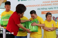 Chủ tịch Hội Chữ thập đỏ thành phố Đà Nẵng Lê Thị Như Hồng trao quà cho các đối tượng yếu thế tại lễ ra mắt. (Ảnh: Trần Lê Lâm/TTXVN)