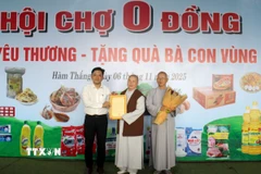 Đại diện Ủy ban Mặt trận Tổ quốc Việt Nam phường Hàm Thắng trao thư cảm ơn cho Ban từ thiện xã hội Giáo hội Phật giáo Việt Nam tỉnh Lâm Đồng. (Ảnh: Hồng Hiếu/TTXVN)