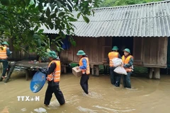 Đồn Biên phòng Làng Ho (Bộ đội Biên phòng Quảng Bình) hỗ trợ, giúp đỡ di dời 10 hộ, 52 người dân bản Mít Cát, xã Kim Thủy, huyện Lệ Thủy đến vị trí an toàn. (Ảnh: TTXVN phát)