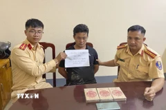 Đối tượng mua bán trái phép ma túy Cháng A Sùng cùng tang vật tại cơ quan Công an. (Ảnh: TTXVN phát)