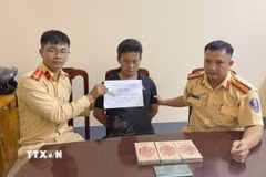 Đối tượng mua bán trái phép ma túy Cháng A Sùng cùng tang vật tại cơ quan Công an. (Ảnh: TTXVN phát)