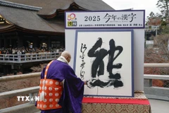 Trụ trì chùa Kiyomizu ở Kyoto (Nhật Bản) Seihan Mori viết chữ Hán "kuma" (nghĩa là gấu) bằng bút lông thư pháp tại sự kiện chữ Hán của năm, ngày 12/12/2025. (Ảnh: Kyodo/TTXVN)