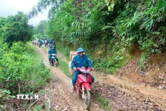 Hành trình chở lương thực, thực phẩm, nhu yếu phẩm bằng xe máy xuyên đại ngàn Pù Huống vào hỗ trợ cho bà con dân bản Na Ngân. (Ảnh: TTXVN phát)