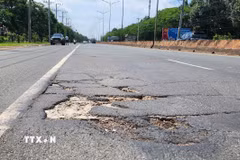 Đường ĐT.741 xuất hiện nhiều "ổ voi, ổ gà" gây nguy hiểm cho người đi đường. (Ảnh: Đậu Tất Thành/TTXVN)