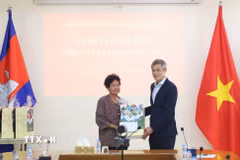 Đại sứ Nguyễn Minh Vũ trao tặng quà Tết cho bà Hà Thị E, có công trong cuộc kháng chiến chống Mỹ cứu nước, được Thủ tướng Chính phủ Việt Nam cấp bằng khen năm 2009. (Ảnh: Huỳnh Thảo/TTXVN)