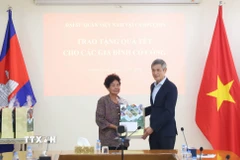 Đại sứ Nguyễn Minh Vũ trao tặng quà Tết cho bà Hà Thị E, có công trong cuộc kháng chiến chống Mỹ cứu nước, được Thủ tướng Chính phủ Việt Nam cấp bằng khen năm 2009. (Ảnh: Huỳnh Thảo/TTXVN)