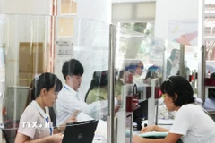 Cán bộ, công chức tại Trung tâm Hành chính công phường Sài Gòn mới đang khẩn trương xử lý hồ sơ. (Ảnh: Hữu Duyên/TTXVN)