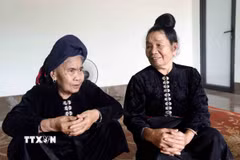 Nữ dân quân Yên Châu Quàng Thị Lói (trái) và Quàng Thị Hổn cùng ôn lại chiến công bắn rơi máy bay Mỹ năm xưa. (Ảnh: Quang Quyết/TTXVN)