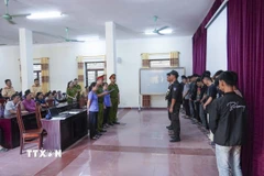 Cơ quan Cảnh sát điều tra Công an tỉnh Điện Biên đọc Quyết định khởi tố vụ án hình sự, khởi tố bị can đối với 18 đối tượng có hành vi gây rối trật tự công cộng. (Ảnh: TTXVN phát)
