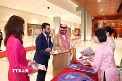Đại biểu quốc tế tham quan, tìm hiểu các ấn phẩm báo chí của Thông tấn xã Việt Nam. (Ảnh: Phương Hoa/TTXVN)