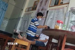 Hộ kinh doanh Huỳnh Khóa Hưng chữa bệnh cho bệnh nhân bằng phương pháp diện chẩn dù không có giấy phép hành nghề. (Ảnh: TTXVN phát)