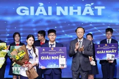Thứ trưởng Thường trực Bộ Giáo dục và Đào tạo Phạm Ngọc Thưởng trao giải Nhất cho các học sinh đạt giải. (Ảnh: Thanh Tùng/TTXVN)