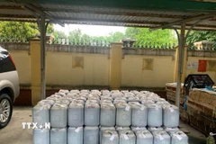 Hàng ngàn lít nước mắm được đóng vào các can nhựa bị lực lượng chức năng phát hiện. (Ảnh: TTXVN phát)