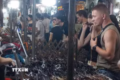 Khách quốc tế yêu thích việc mua sắm quà lưu niệm tại chợ đêm phố cổ Hà Nội. (Ảnh: Tuyết Mai/TTXVN)