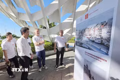 Phó Chủ tịch UBND thành phố Đà Nẵng Trần Chí Cường và các đại biểu tham quan triển lãm ảnh tại sự kiện. (Ảnh: Trần Lê Lâm/TTXVN)