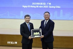 Ông Lê Minh Trí, Chánh án Tòa án Nhân dân Tối cao Việt Nam trao quà lưu niệm tặng Tòa án Nhân dân cấp cao tỉnh Quảng Đông, Trung Quốc. (Ảnh: Công Tuyên/TTXVN)