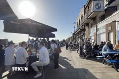 Người dân thưởng thức đồ uống tại các pub ven sông Thames trong ngày nắng nóng. (Ảnh: Hương Giang/TTXVN)